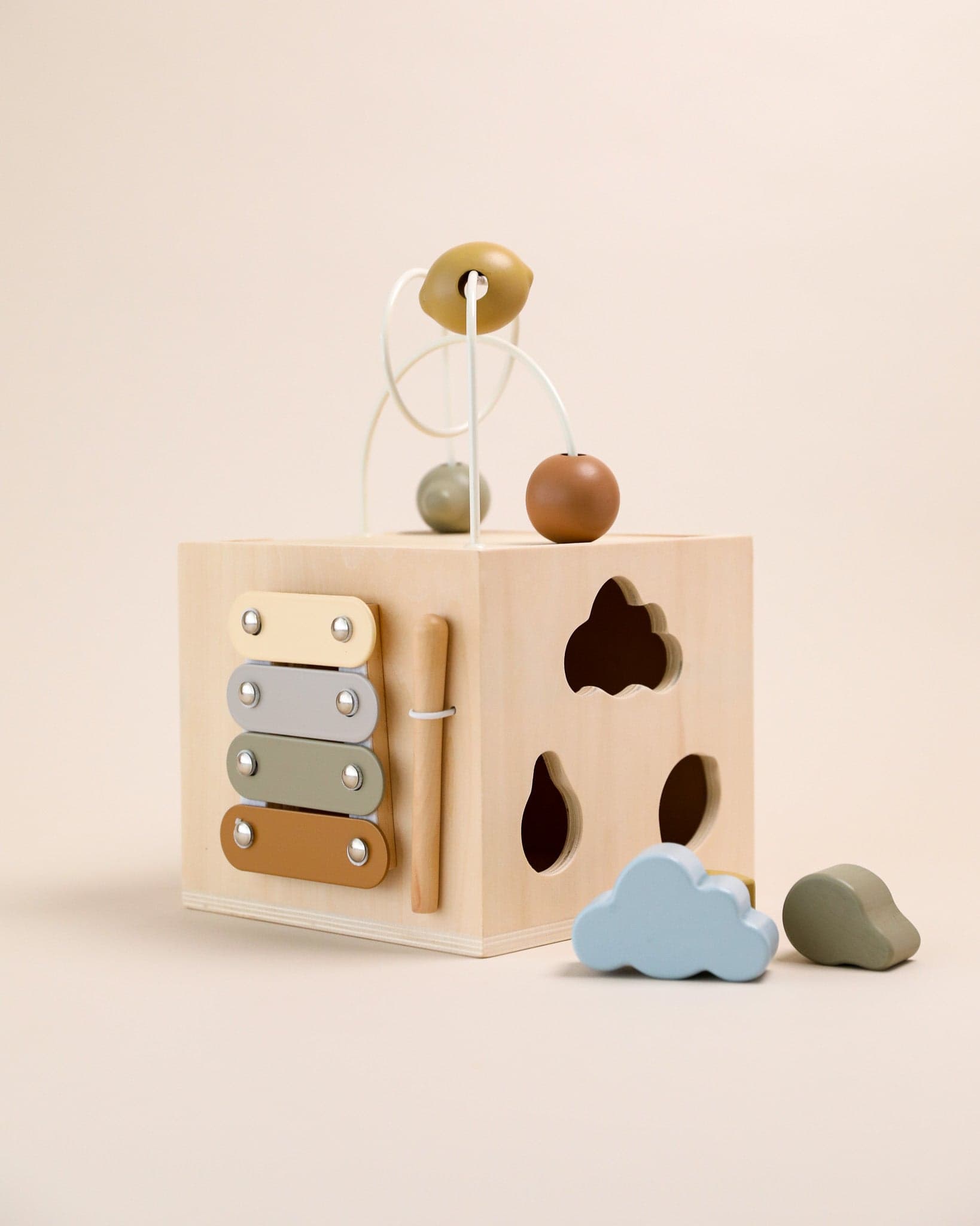 Konges Sloejd Montessori Wooden Activity Cube in a serene nursery setting.