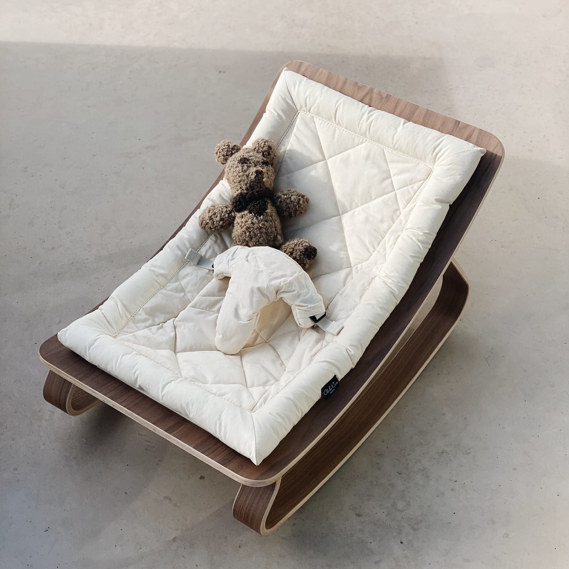 Charlie Crane Paris LEVO Baby Rocker in walnut with natural cotton cover.