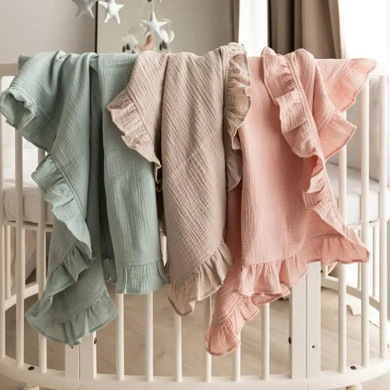 Organic Cotton Ruffled Muslin Baby Swaddle Blanket in soft colors.