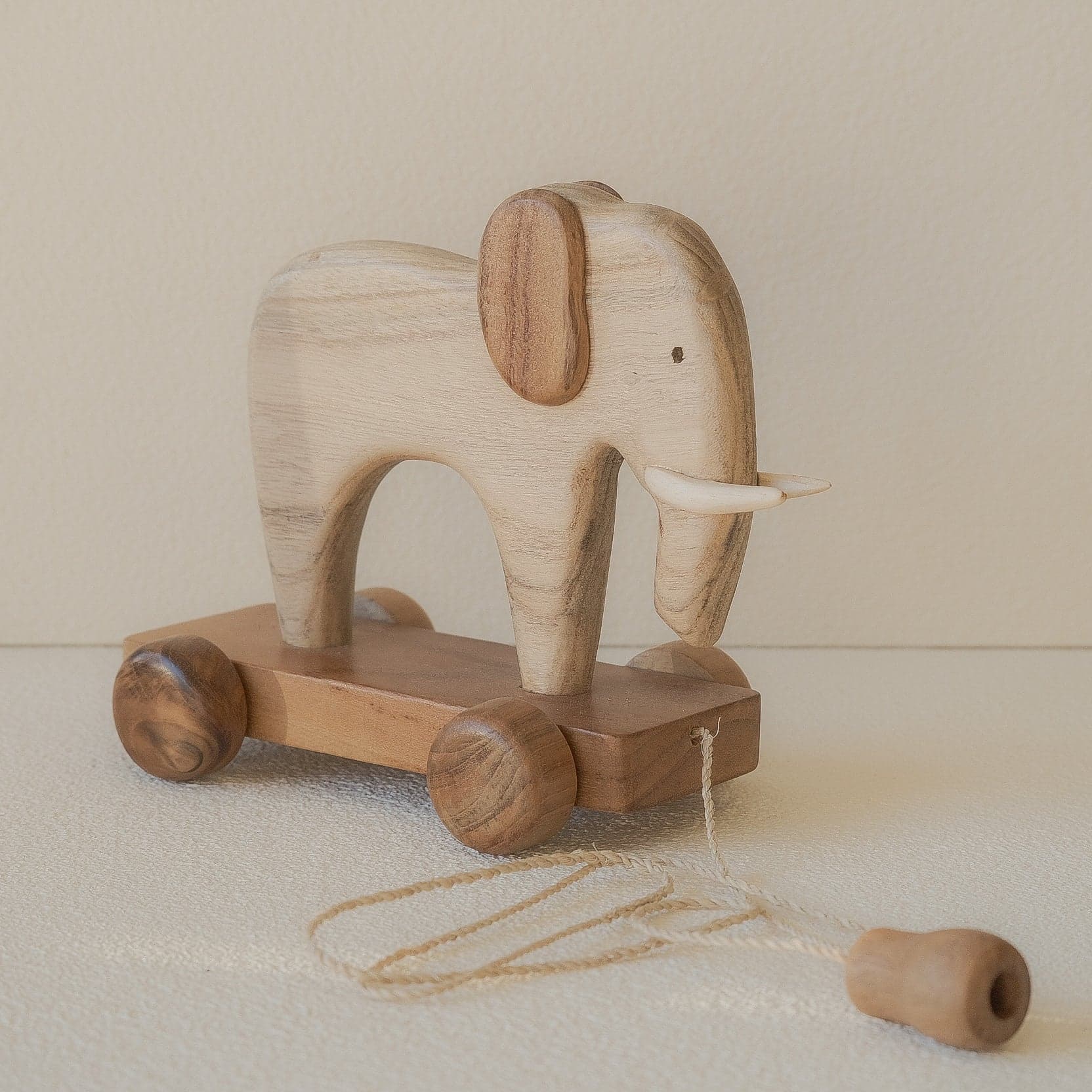 Handcrafted wooden elephant pull-along toy for toddlers.